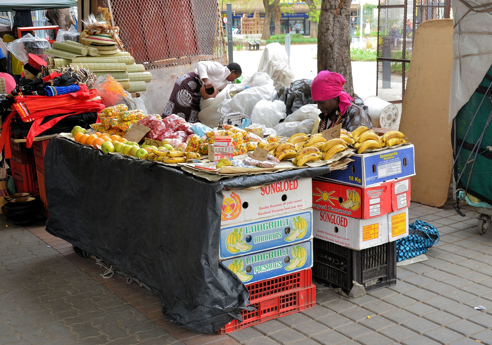 A street vendor’s fruit stall with bananas, apples, oranges, pineapples and woven baskets in Joubert Street, Johannesburg.